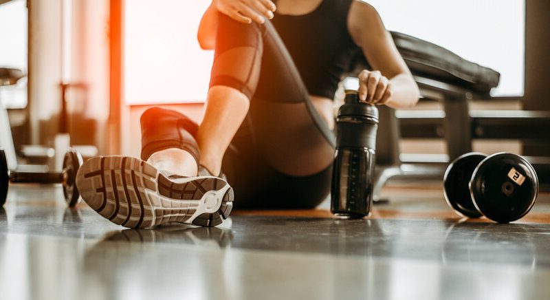 Sporty woman drinking aqua in a gym 